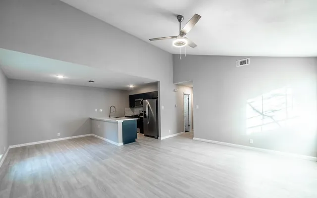 a view of an empty room with a fireplace and a window