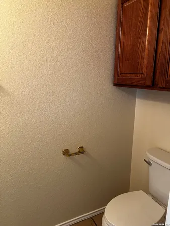 a white toilet sitting next to a wooden cabinet