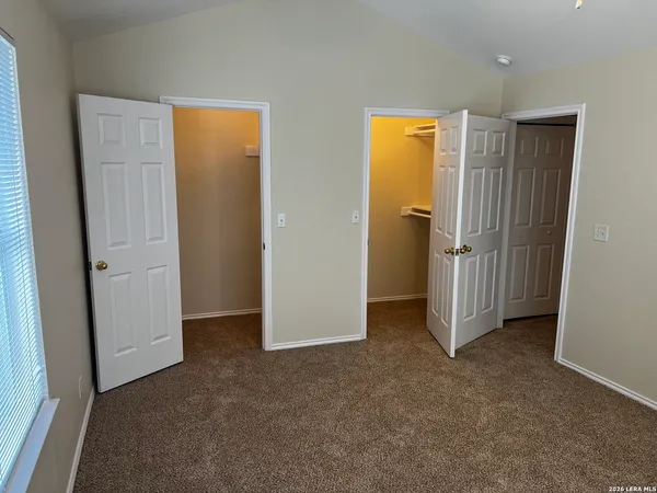 an empty room with closet and a bathroom