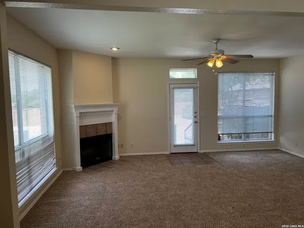 a view of an empty room with window and fire place
