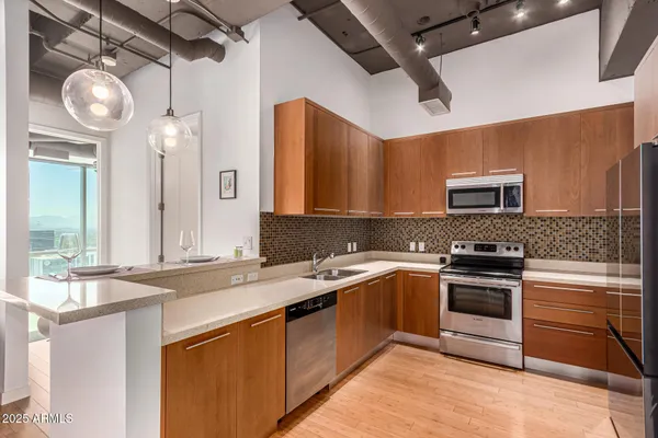 a kitchen with stainless steel appliances granite countertop a sink a stove top oven and refrigerator