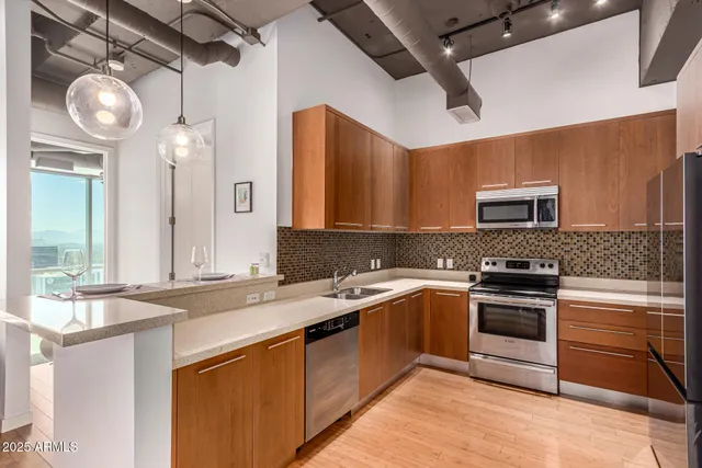 a kitchen with stainless steel appliances granite countertop a sink a stove top oven and refrigerator