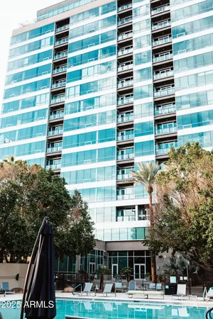 a front view of a building with streets and trees