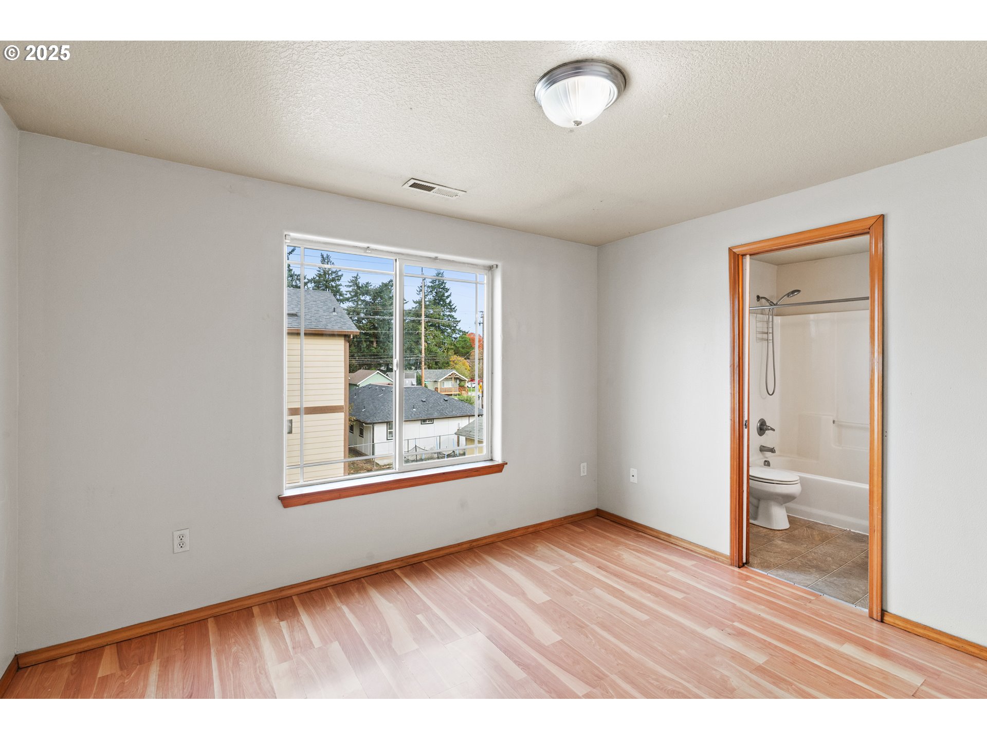 2518 Southeast 130th Avenue, Unit 5 Portland, OR 97236 - Photo 11 of 13 a view of an empty room with wooden floor and a window