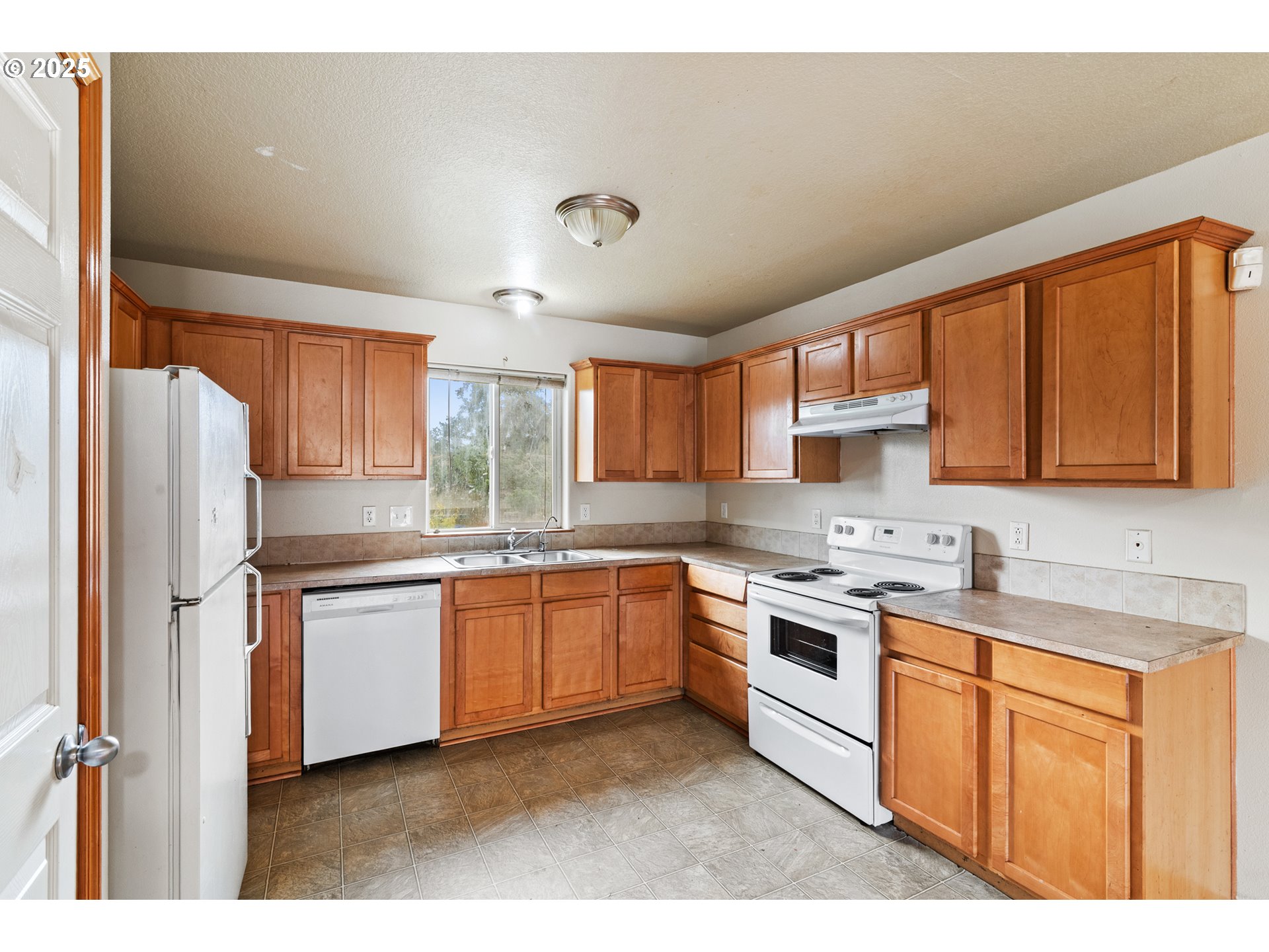 2518 Southeast 130th Avenue, Unit 5 Portland, OR 97236 - Photo 5 of 13 a kitchen with stainless steel appliances granite countertop a stove sink refrigerator and cabinets