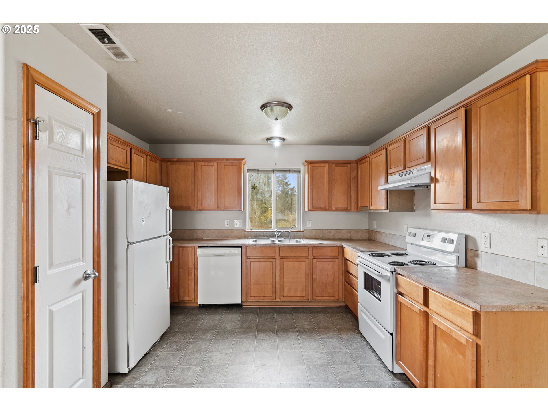 2518 Southeast 130th Avenue, Unit 5 Portland, OR 97236 - Photo 6 of 13 a kitchen with stainless steel appliances granite countertop a refrigerator a sink dishwasher a stove and white countertops with wooden floor