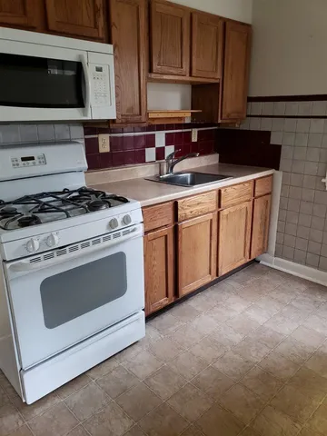 a kitchen with granite countertop a stove sink and cabinets