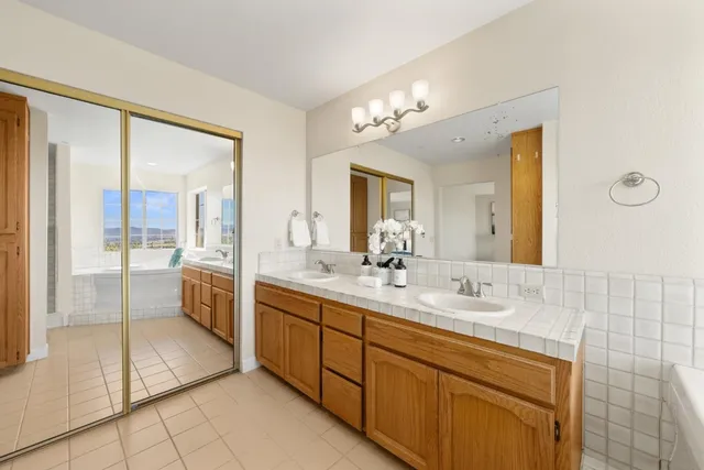 a bathroom with a granite countertop sink and a bathtub