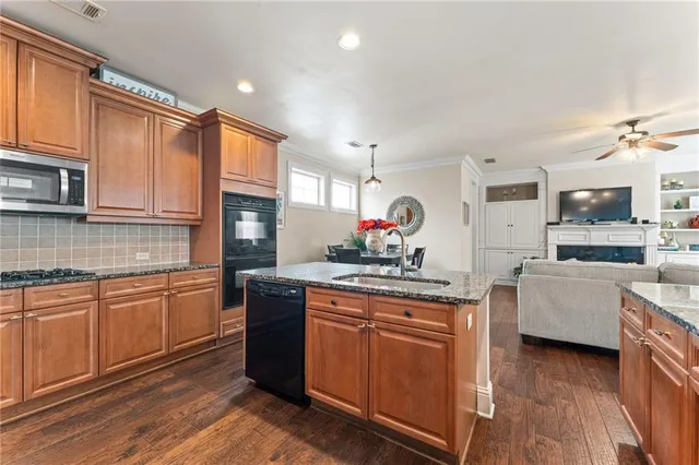 a kitchen with granite countertop a sink stove and cabinets
