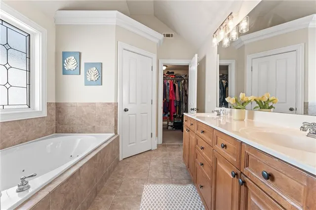a bathroom with a granite countertop tub sink and mirror