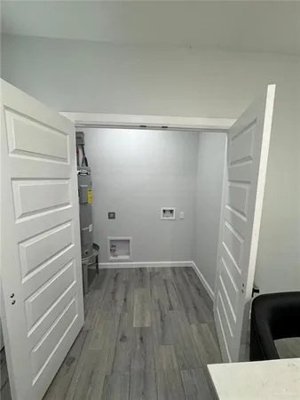 a view of empty room with wooden floor and window