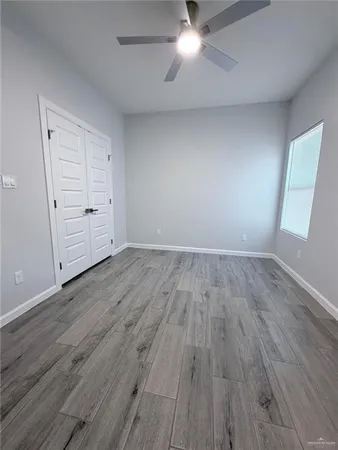 an empty room with wooden floor and closet