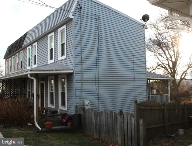 a view of a house with a yard and wooden fence