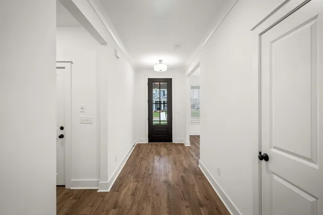 a view of an empty room with wooden floor fireplace and a window