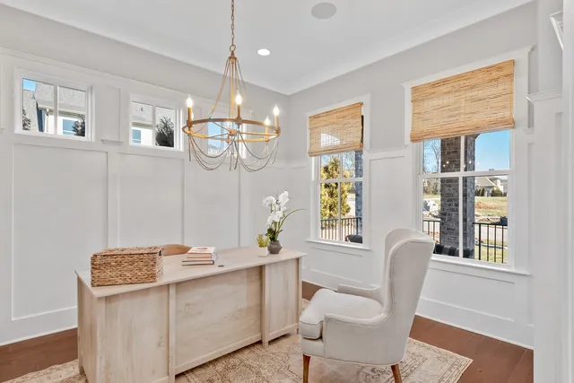 a dining room with furniture a chandelier and wooden floor