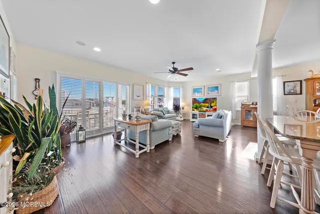 a living room with furniture kitchen view and a large window