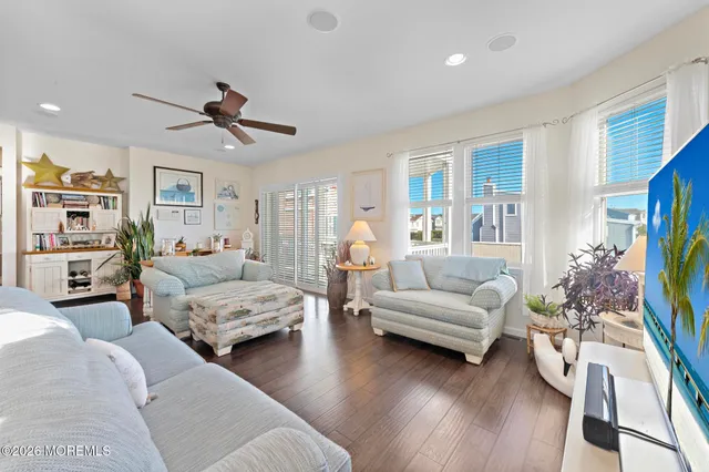 a kitchen with stainless steel appliances granite countertop a dining table chairs a sink and a refrigerator