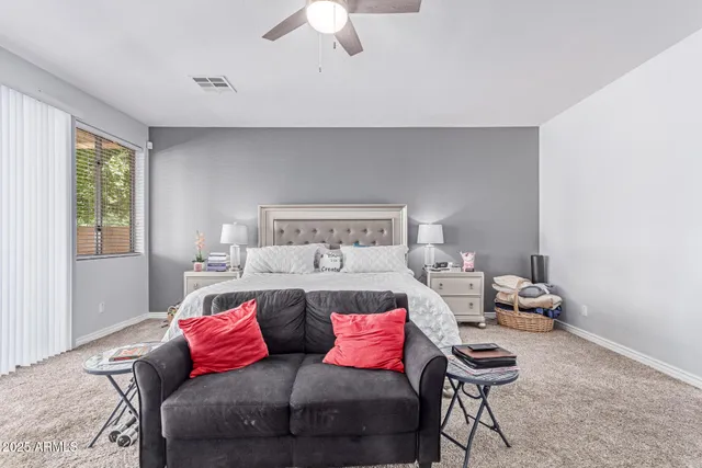 an empty room with a ceiling fan and carpet