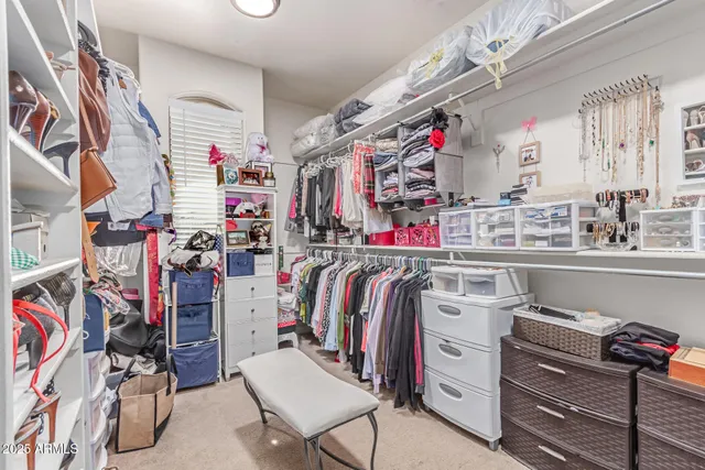 a view of walk in closet with clothes