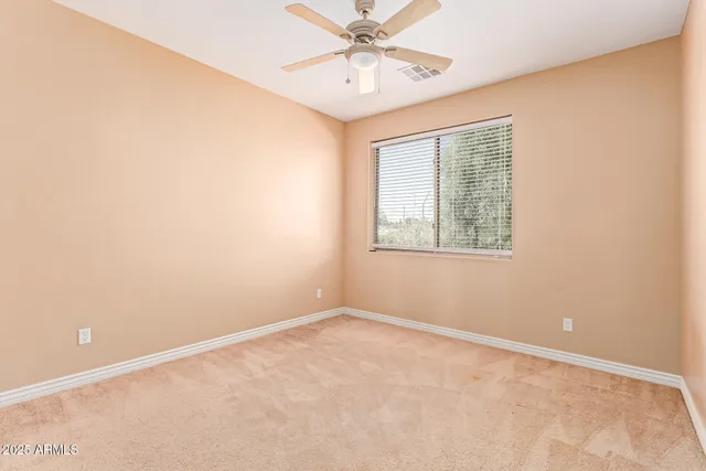 a bathroom with a granite countertop toilet a sink a mirror a shower a vanity and a window