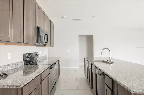 a kitchen with stainless steel appliances granite countertop a sink stove and cabinets