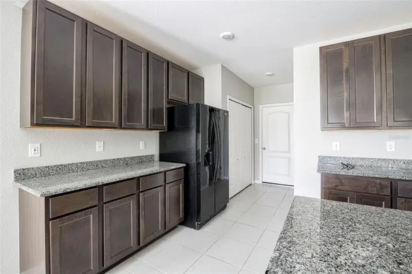 a kitchen with stainless steel appliances granite countertop a refrigerator and a stove top oven