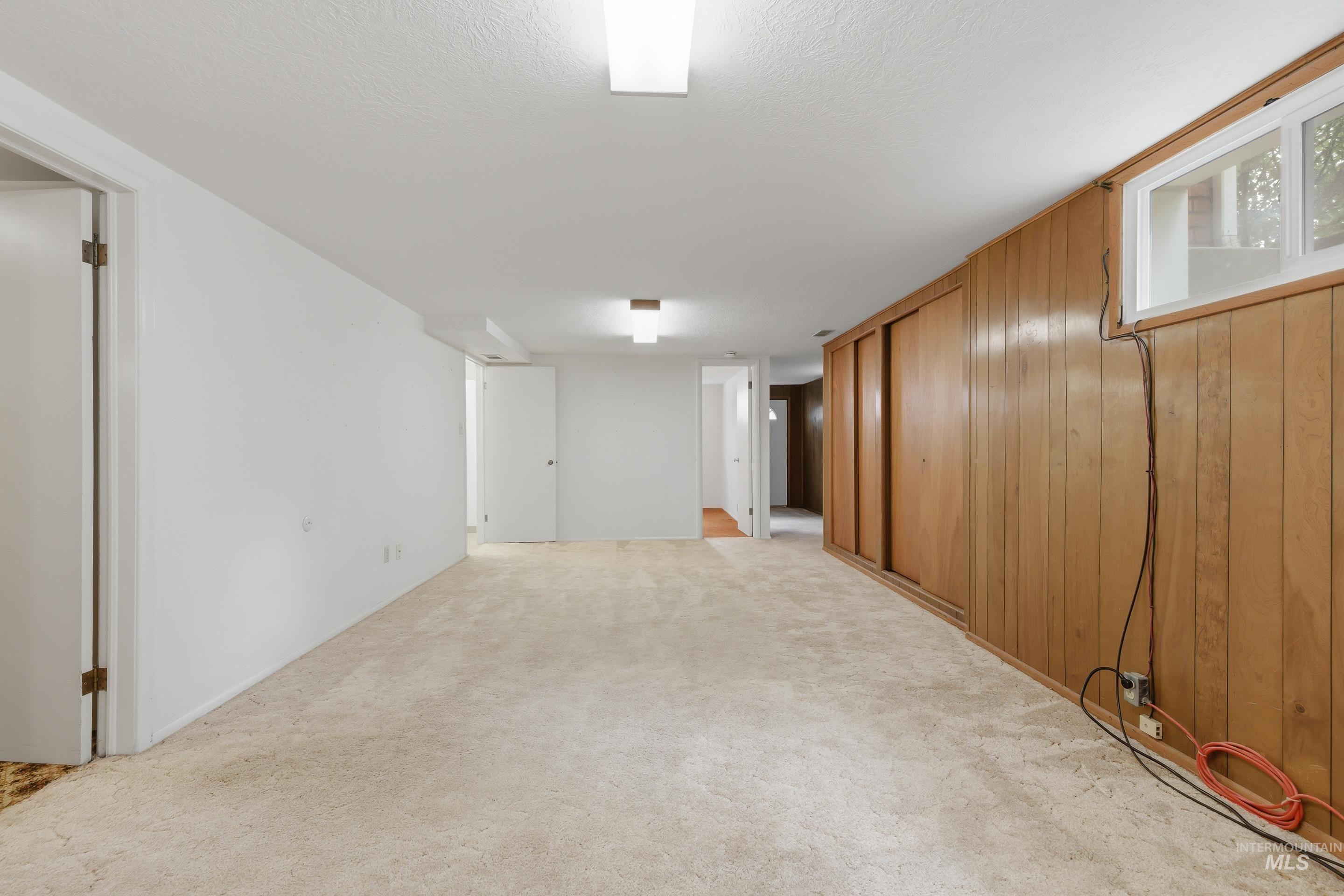 504 West Howe Street Boise, ID 83706 - Photo 40 of 47 Carpeted room featuring a white painted wall and wood paneling