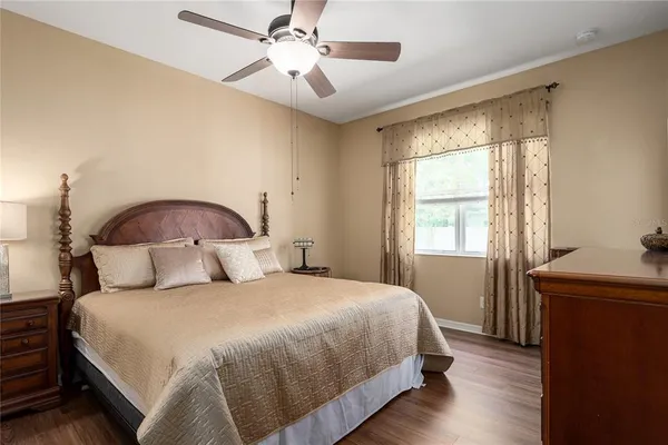 a spacious bedroom with a bed and wooden floor