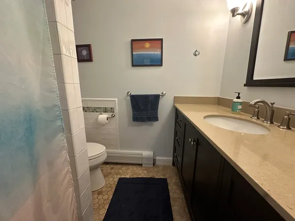 a bathroom with a granite countertop toilet sink and mirror