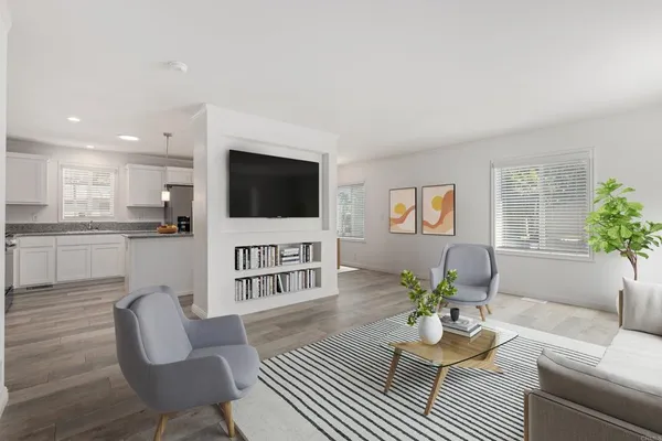 a living room with furniture a flat screen tv and a potted plant