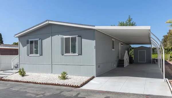 a view of a swimming pool with a lawn chairs and palm trees