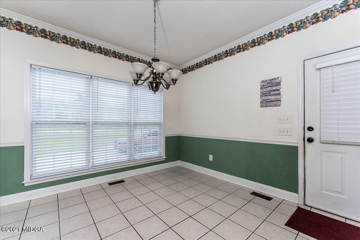 7455 Columbus Road Lizella, GA 31052 - Photo 12 of 32 a view of a livingroom with a chandelier fan and windows