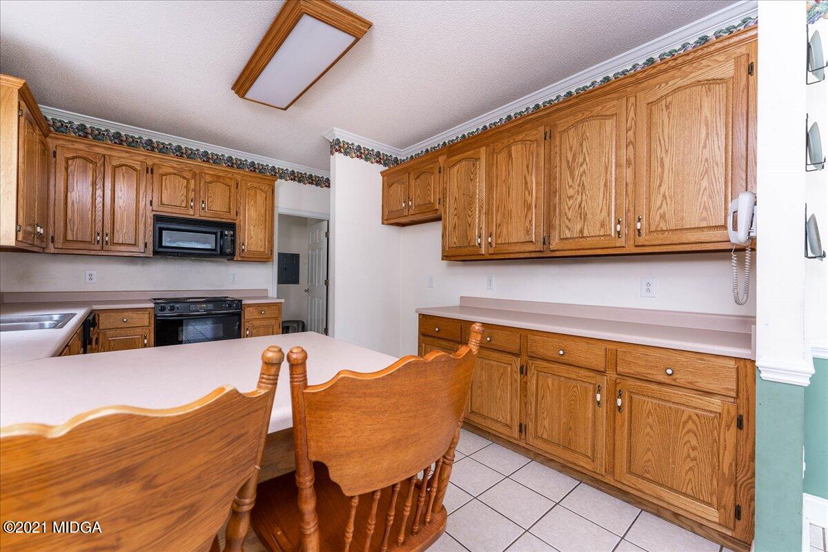 7455 Columbus Road Lizella, GA 31052 - Photo 14 of 32 a kitchen with stainless steel appliances granite countertop a stove a sink and a microwave