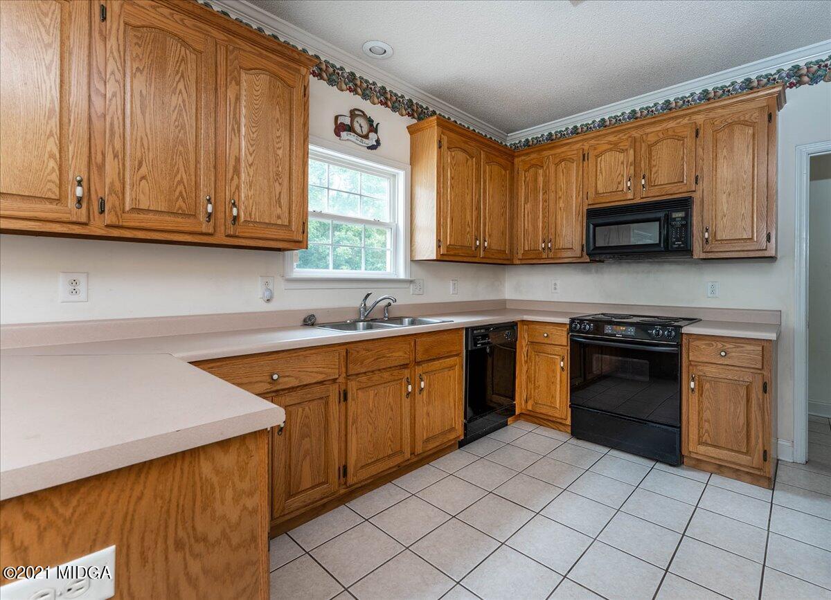 7455 Columbus Road Lizella, GA 31052 - Photo 15 of 32 a kitchen with stainless steel appliances granite countertop a sink and cabinets