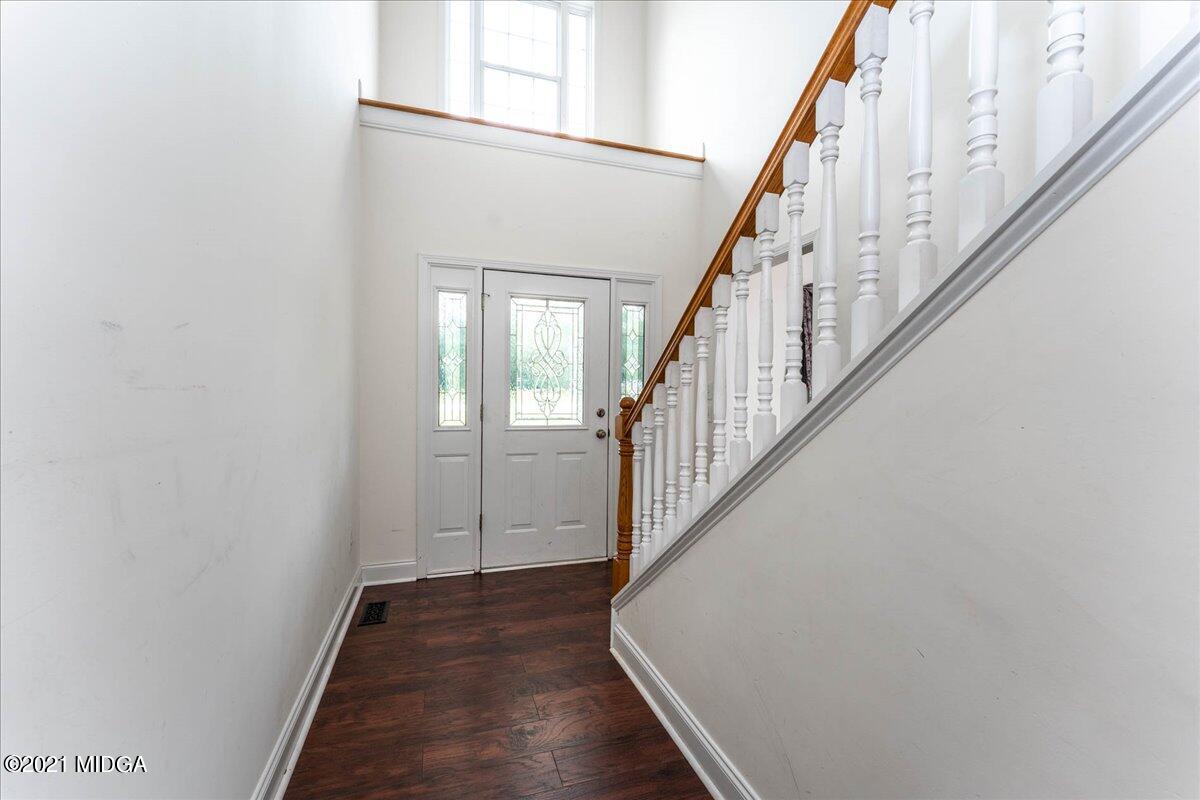 7455 Columbus Road Lizella, GA 31052 - Photo 18 of 32 a view of a hallway with wooden floor and staircase