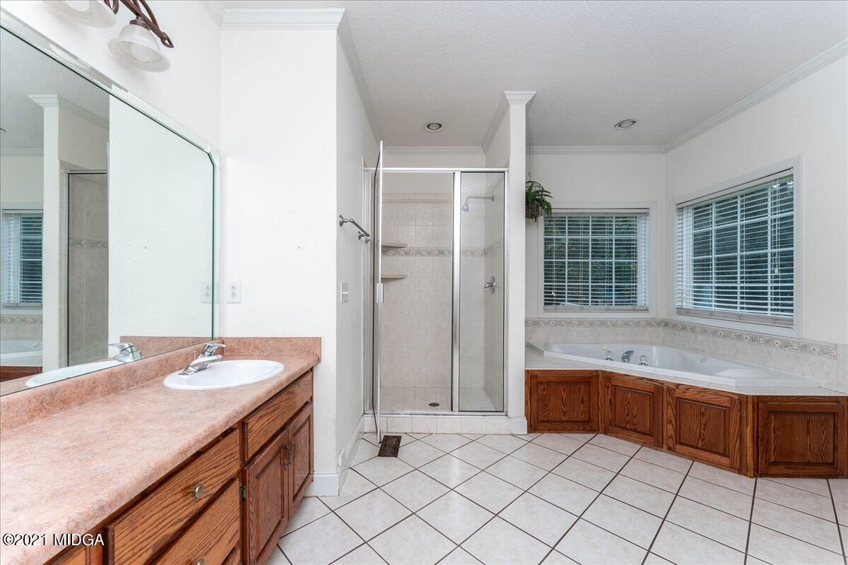 7455 Columbus Road Lizella, GA 31052 - Photo 21 of 32 a spacious bathroom with a granite countertop sink and a bathtub