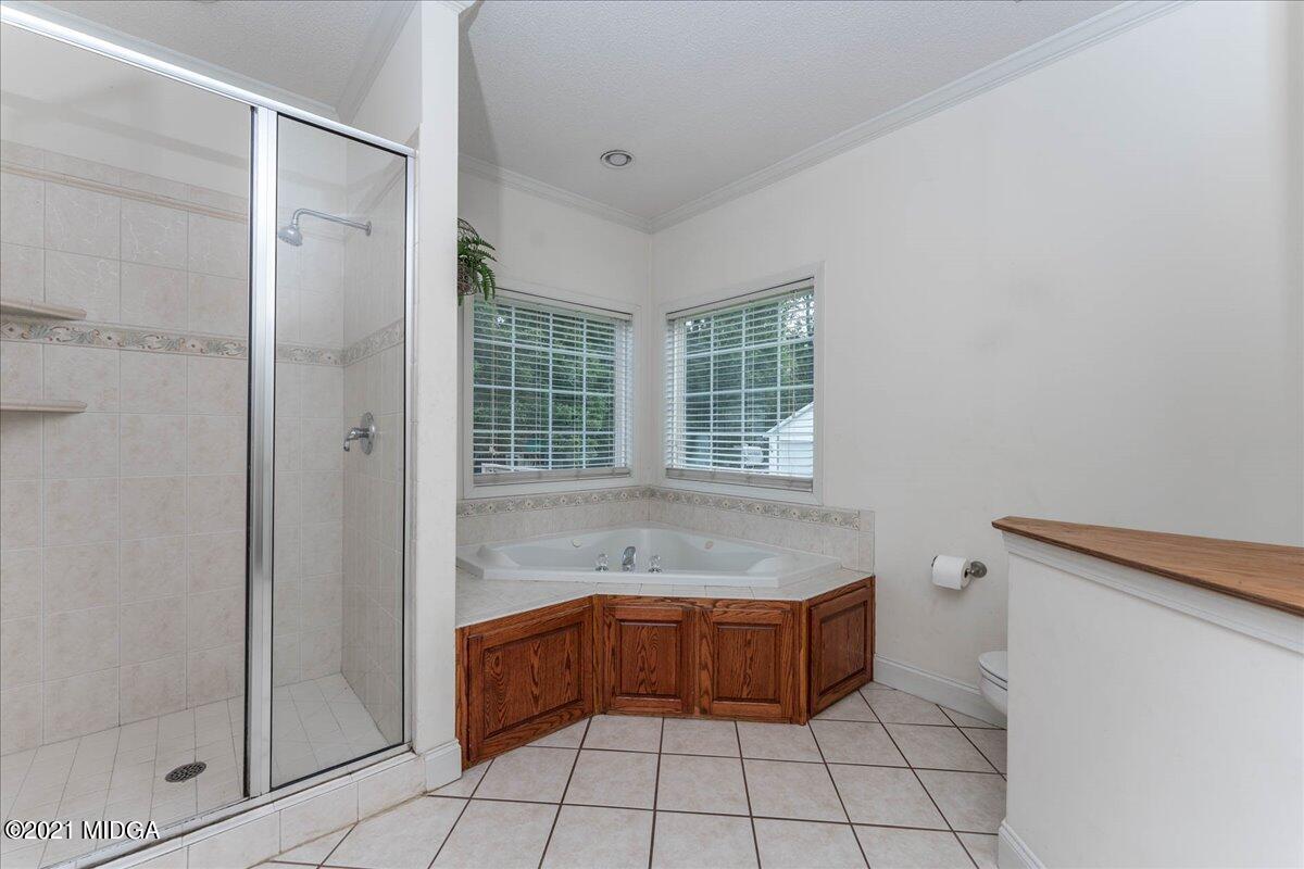 7455 Columbus Road Lizella, GA 31052 - Photo 22 of 32 a bathroom with a tub shower and sink