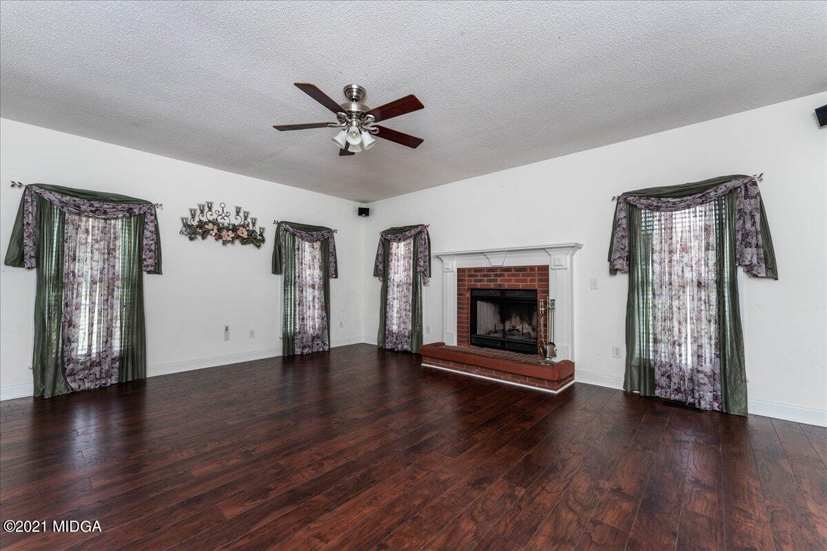 7455 Columbus Road Lizella, GA 31052 - Photo 25 of 32 a view of an empty room with wooden floor fireplace and a window