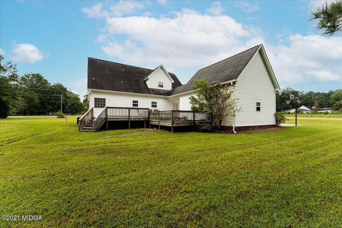 7455 Columbus Road Lizella, GA 31052 - Photo 10 of 32 a view of a big house with a big yard and large trees