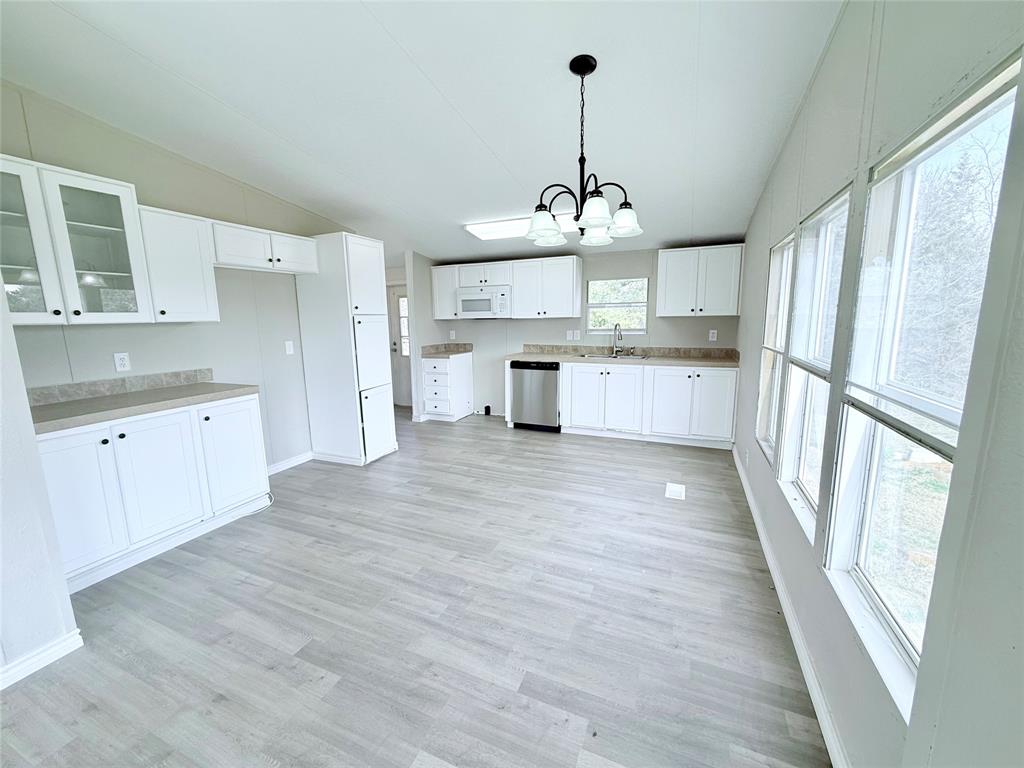 6100 Preston Road Denison, TX 75020 - Photo 4 of 20 a large kitchen with cabinets wooden floor and stainless steel appliances