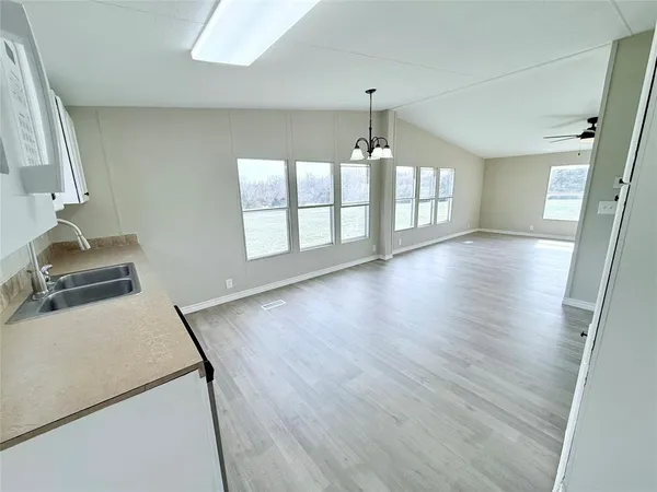 a view of a room with wooden floor and chandelier