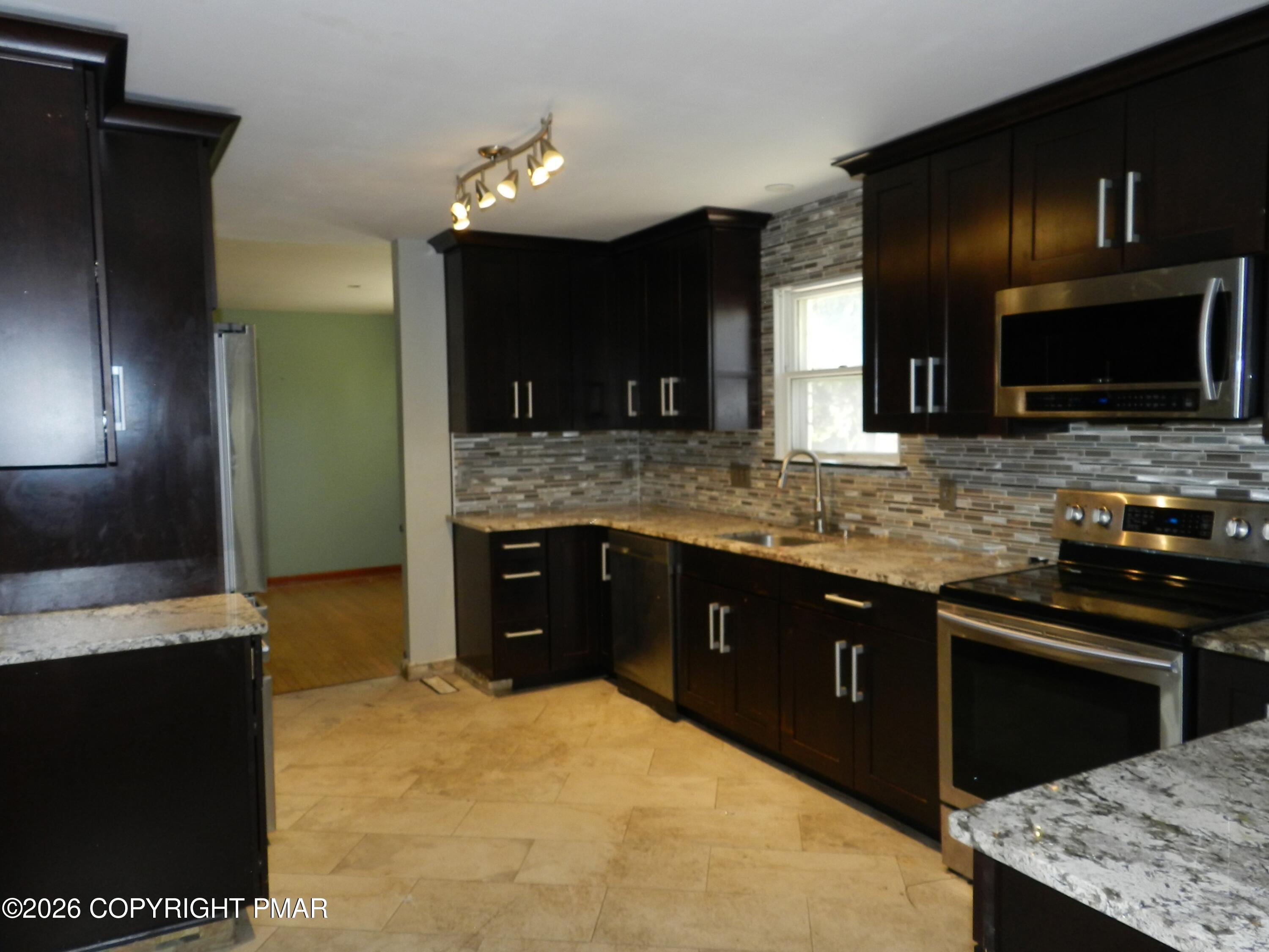 1055 Pine Tree Drive Slatington, PA 18080 - Photo 7 of 38 a kitchen with stainless steel appliances granite countertop a stove a sink and a microwave