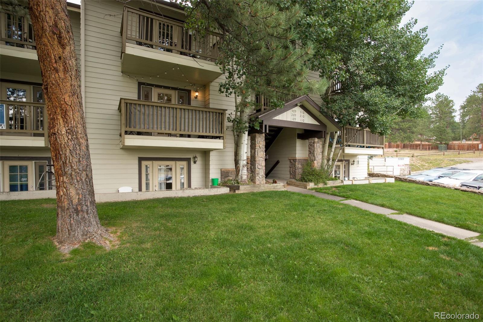 29656 Buffalo Park Road, Unit 209 Evergreen, CO 80439 - Photo 20 of 22 a front view of a house with a yard