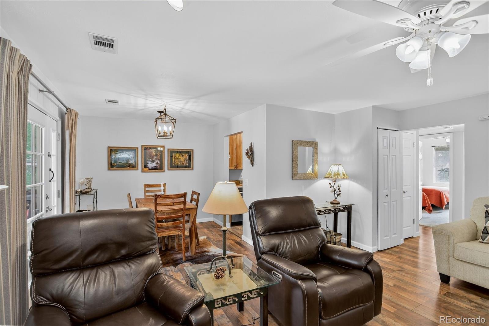 29656 Buffalo Park Road, Unit 209 Evergreen, CO 80439 - Photo 5 of 22 a living room with furniture a wooden floor and chandelier