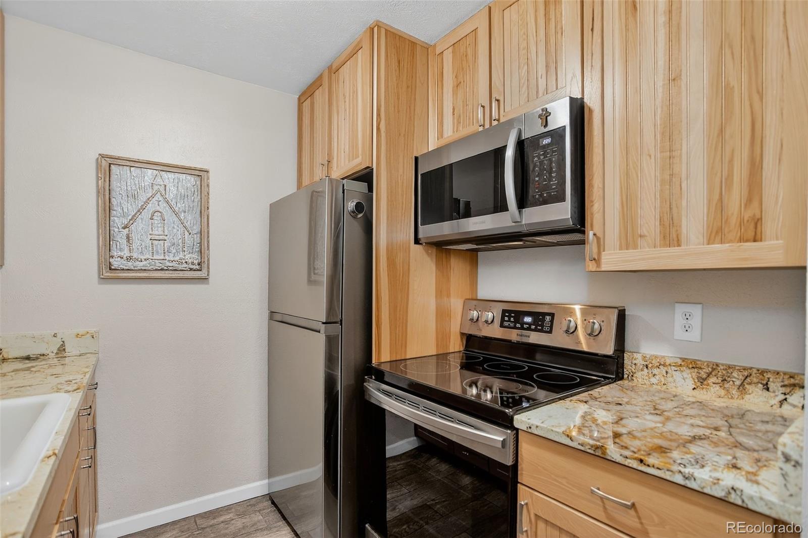 29656 Buffalo Park Road, Unit 209 Evergreen, CO 80439 - Photo 8 of 22 a kitchen with stainless steel appliances white cabinets and a stove top oven