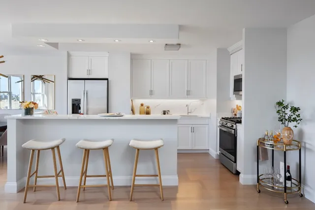 a kitchen with cabinets and chairs