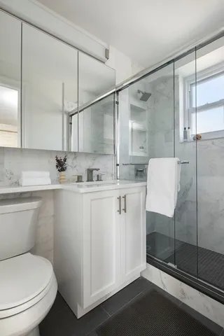 a bathroom with a sink toilet and shower
