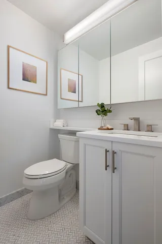 a bathroom with a sink toilet and mirror