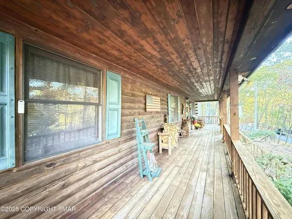 a view of a living room and balcony with wooden floor and furniture