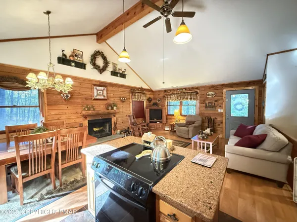 a view of a dining room with furniture a chandelier and large windows